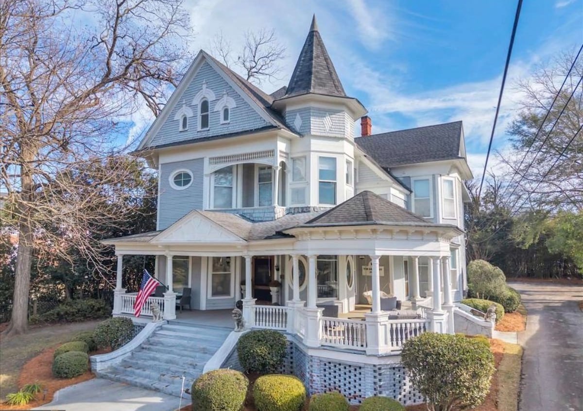 The Grey Lady: a slate-blue 1910 Victorian with a corner turret, oval windows and a wraparound porch